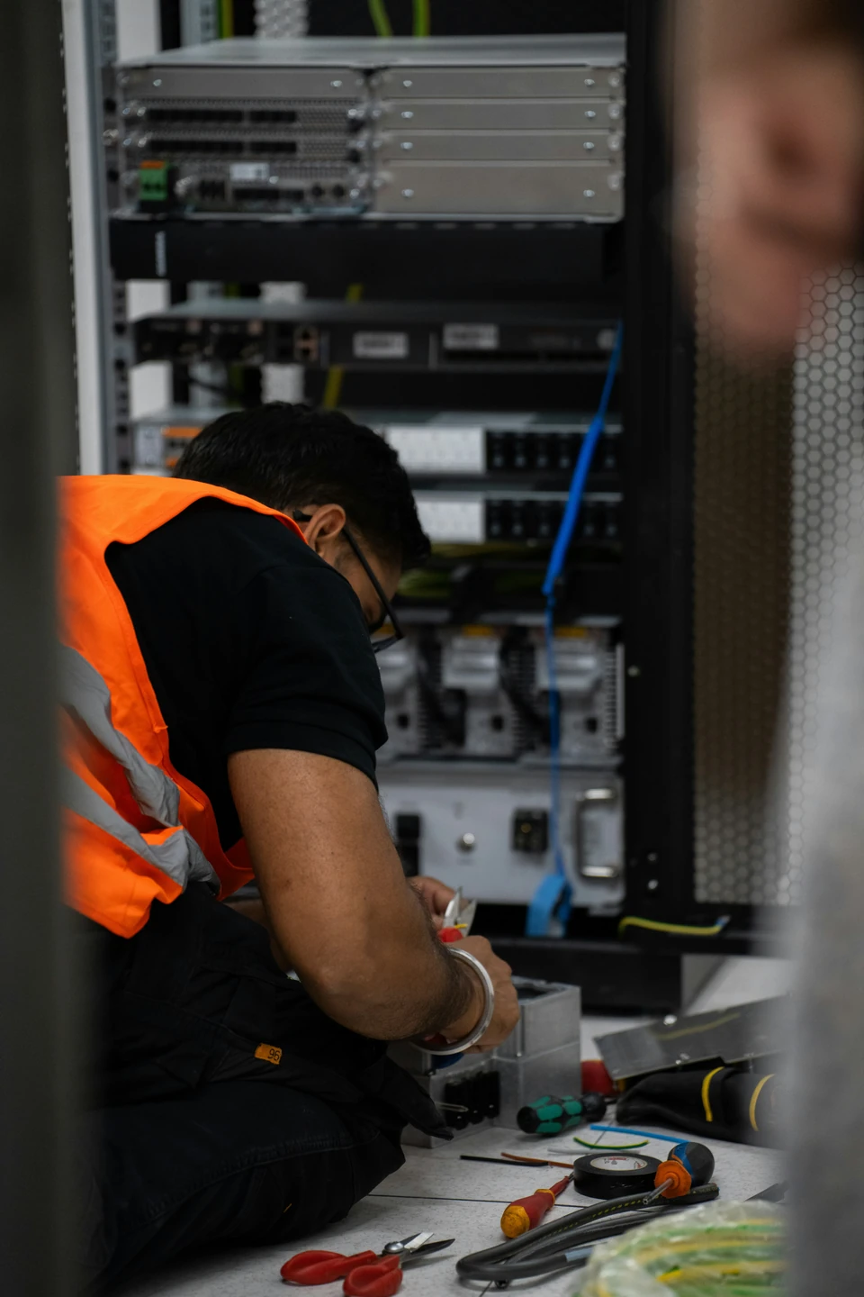 Technician working on equipment in a server rack
